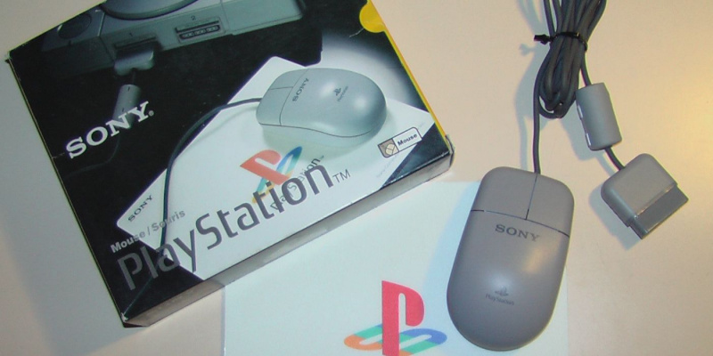   En PlayStation-mus sitter ved siden av emballasjen