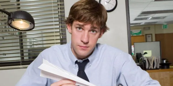紙飛行機を持ち、The Office のカメラを見ているジム